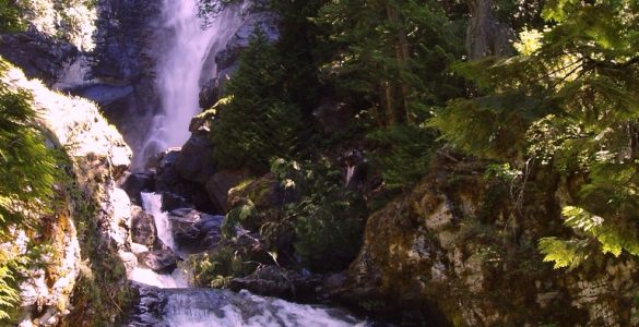 A cascading waterfall surrounded by rocks and trees.