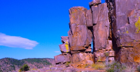 A solitary rock formation stands stoic against the backdrop of a vast desert landscape. The forces of nature have sculpted this ancient rock formation into a mesmerizing work of art, its weathered beauty a testament to the passage of time.