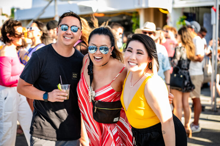 People standing together under a sunny sky smiling in a crowd